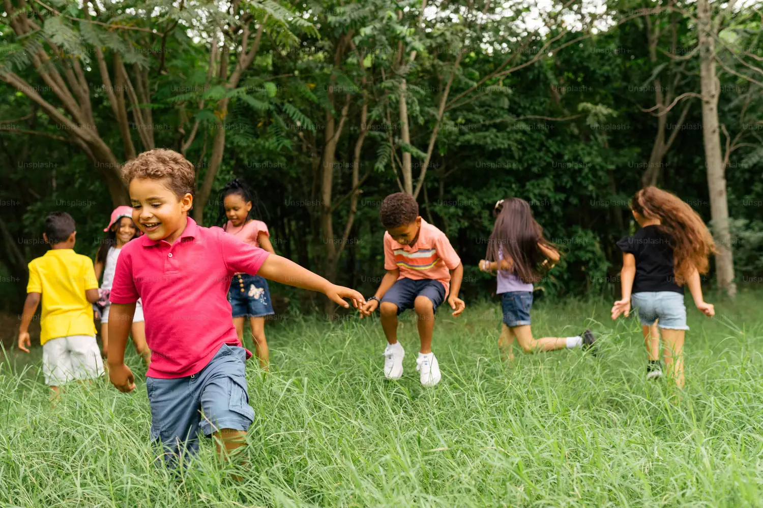 Niños jugando y corriendo al aire libre en el pasto, sin pantallas